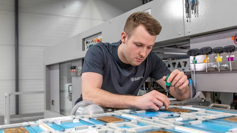 Marbach Mitarbeiter beim Einrichten einer Stanzform mit Prägung. | © Marbach Group