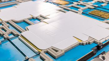 Der gestanzte Kartonage Zuschnitt mit Hochprägung liegt auf einer Marbach-Stanzform mit Prägeklischee | © Marbach Group