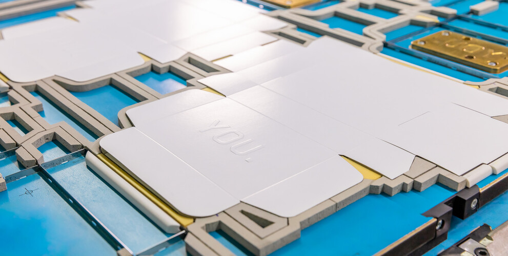 The die-cut paperboard blank with embossing lies on a Marbach cutting-die with embossing plate. | © Marbach Group