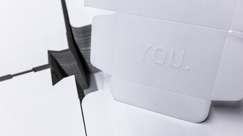 Die-cut paperboard packaging with embossing on a stack of finished blanks | © Marbach Group