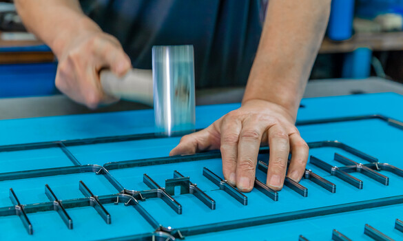 Inserting a cutting rule in corrugated board cutting-die | Marbach Group | © Marbach Group Insertion of a cutting rule into the corrugated board cutting-die at Marbach. | © Marbach Group